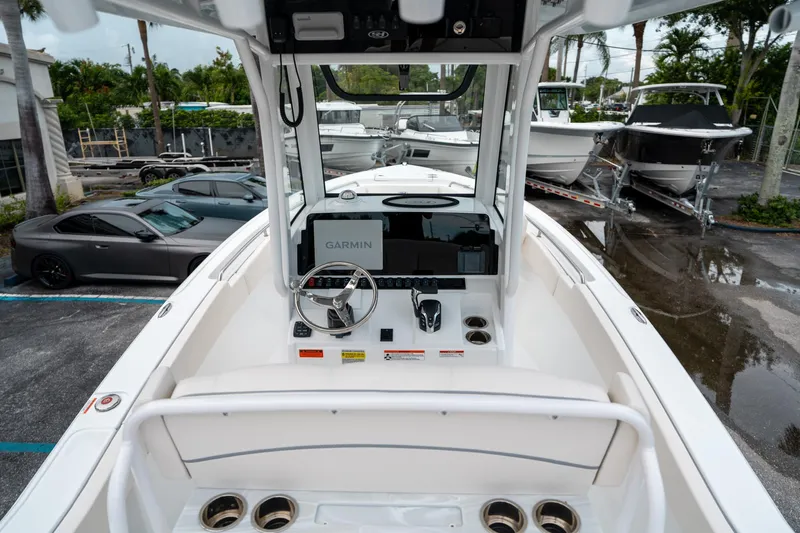 Slide: The Image of 2025 Sea Hunt Ultra 239 SE boat interior with Garmin navigation system, parked near other boats. - 10