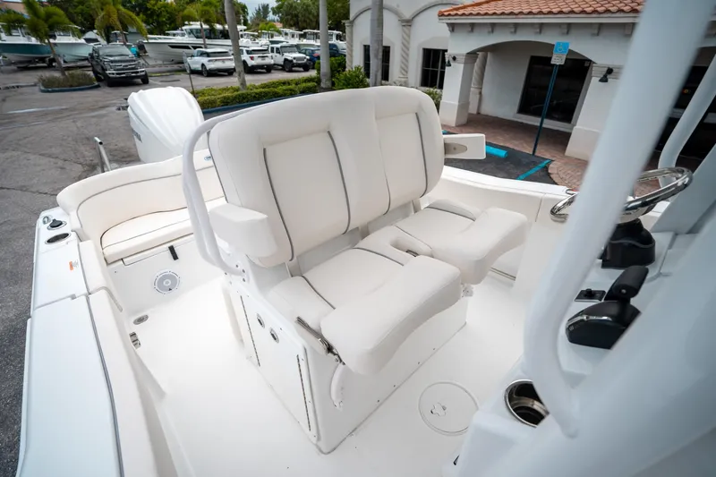 Slide: The Image of 2025 Sea Hunt Ultra 239 SE boat interior with white seating and helm. - 28