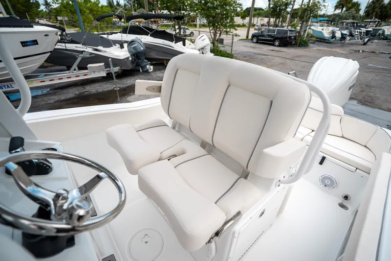 Slide: The Image of 2025 Sea Hunt Ultra 239 SE boat interior with white seating and steering wheel. - 29