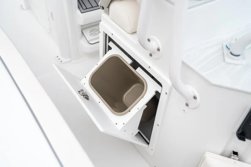 Slide: The Image of Storage compartment on 2025 Sea Hunt Ultra 239 SE boat, featuring a built-in trash bin. - 33
