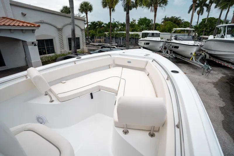 Slide: The Image of 2025 Sea Hunt Ultra 239 SE boat interior with white seating, parked outdoors. - 38
