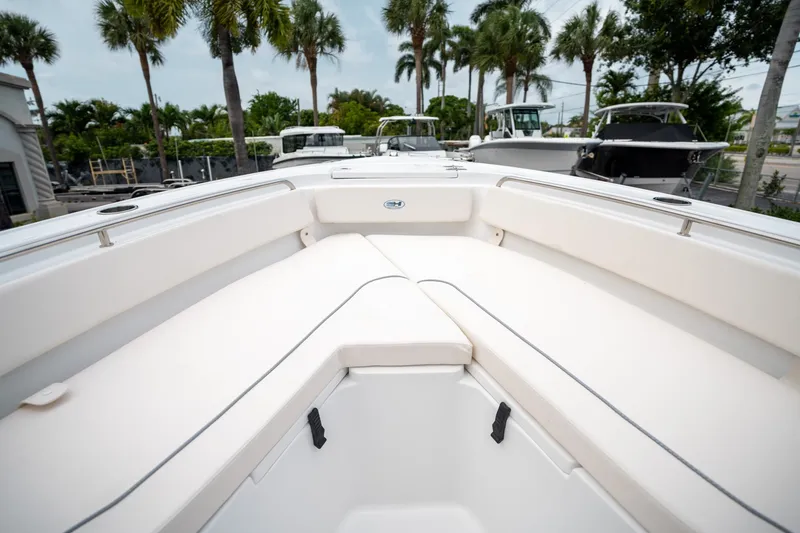 Slide: The Image of 2025 Sea Hunt Ultra 239 SE boat interior with white seating and palm trees in the background. - 39