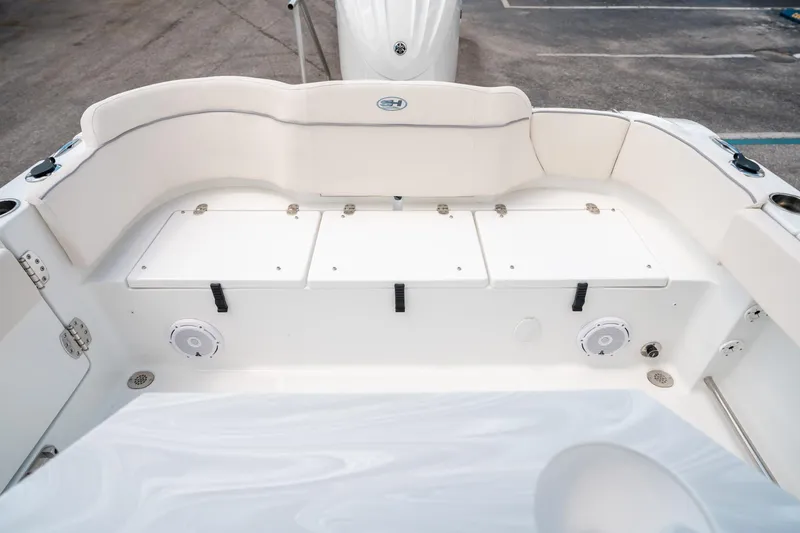 Slide: The Image of 2025 Sea Hunt Ultra 239 SE boat interior with white seating and storage compartments. - 13