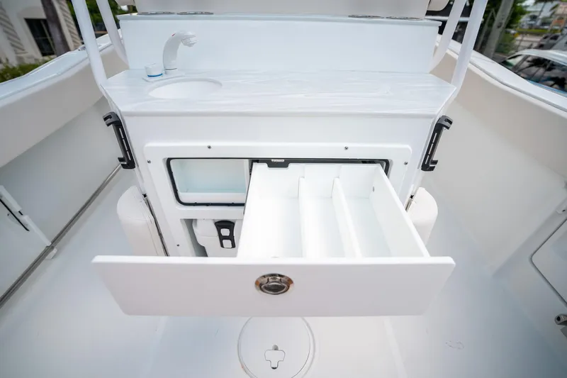 Slide: The Image of Interior of 2025 Sea Hunt Ultra 239 SE boat with open storage compartment and sink. - 17