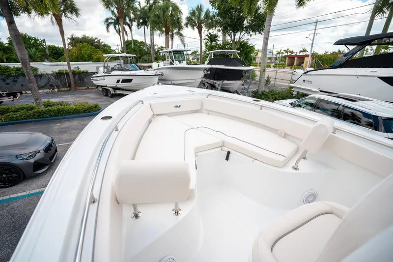 Slide: The Image of 2025 Sea Hunt Ultra 239 SE boat with spacious seating, parked near other boats and cars. - 35