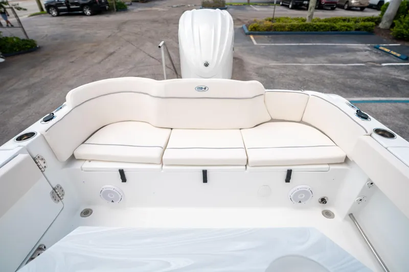 Slide: The Image of 2025 Sea Hunt Ultra 239 SE boat with white cushioned seating and cup holders. - 10