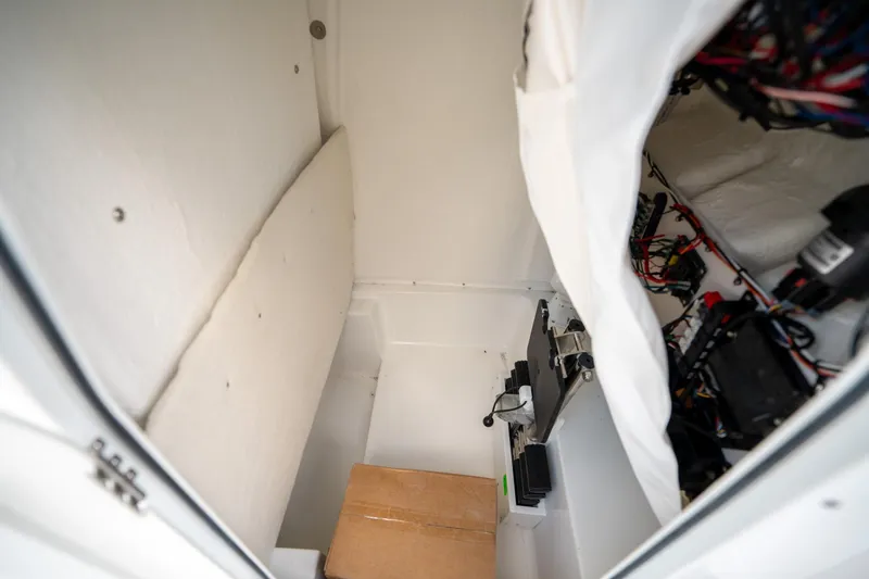 Slide: The Image of Interior view of 2025 Sea Hunt Ultra 239 SE boat compartment with wiring and equipment. - 37