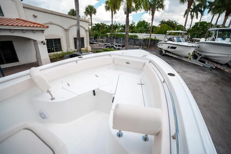Slide: The Image of 2025 Sea Hunt Ultra 239 SE boat interior with seating, docked near palm trees. - 42
