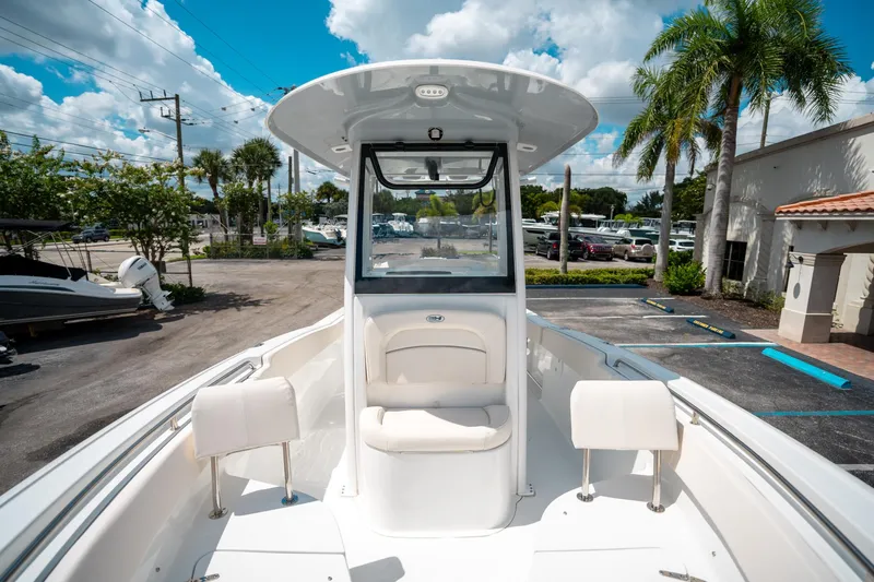 Slide: The Image of 2025 Sea Hunt Ultra 239 SE boat, center console, parked outdoors under a blue sky. - 49