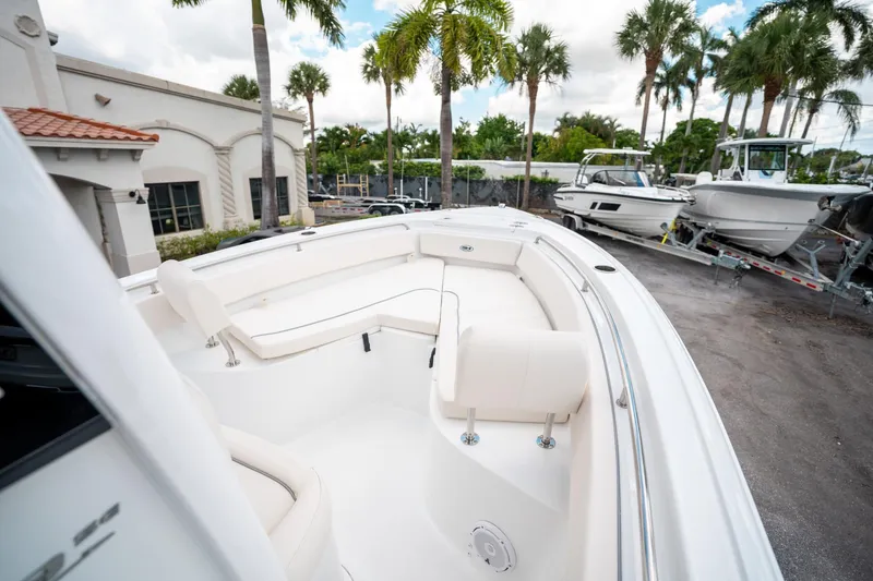 Slide: The Image of 2025 Sea Hunt Ultra 239 SE boat with spacious seating, parked near palm trees. - 34