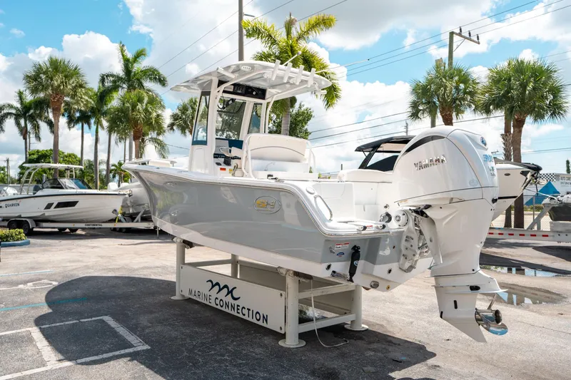 Slide: The Image of 2025 Sea Hunt Ultra 239 SE boat displayed outdoors with palm trees in the background. - 4