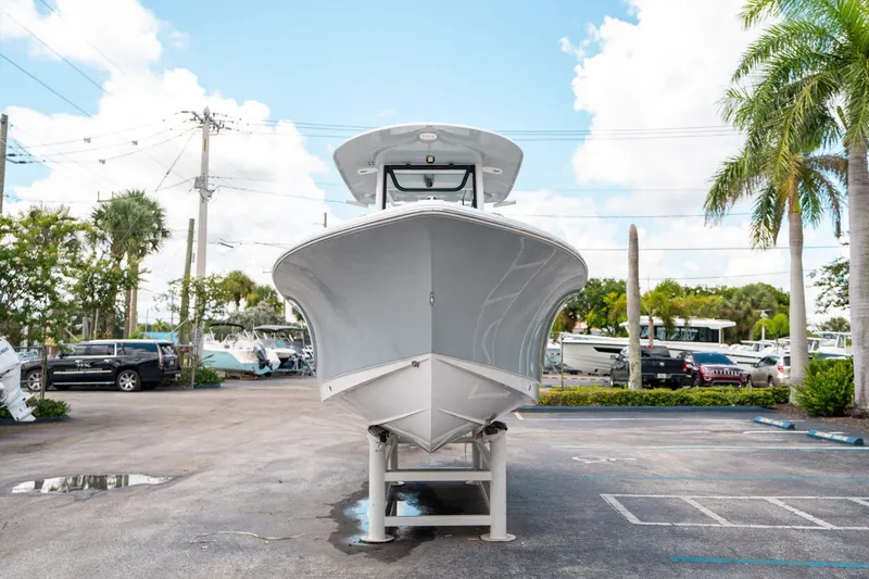 Slide: The Image of 2025 Sea Hunt Ultra 239 SE boat displayed outdoors, surrounded by palm trees and parked cars. - 7