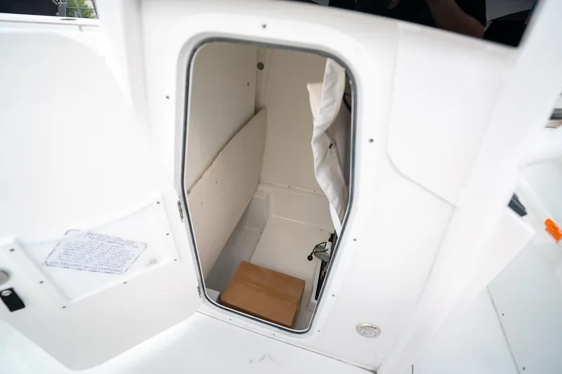 Slide: The Image of 2025 Sea Hunt Ultra 239 SE boat storage compartment, open door view. - 36