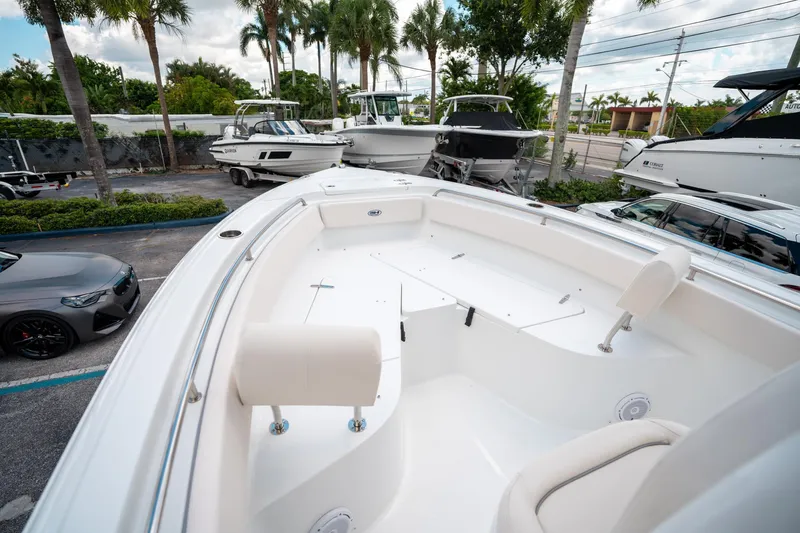 Slide: The Image of 2025 Sea Hunt Ultra 239 SE boat interior with seating, parked among other boats. - 41
