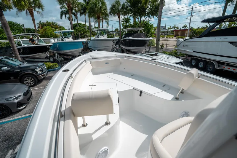 Slide: The Image of 2025 Sea Hunt Ultra 239 SE boat interior with seating, parked among other boats and cars. - 39