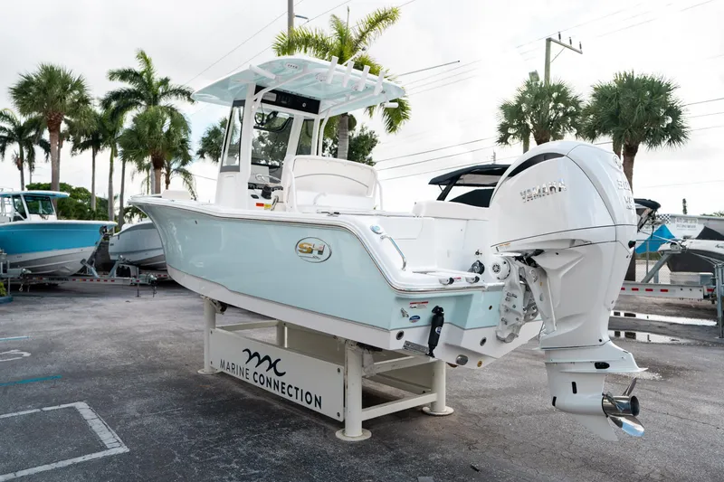 Slide: The Image of 2025 Sea Hunt Ultra 239 SE boat displayed outdoors with palm trees in the background. - 4