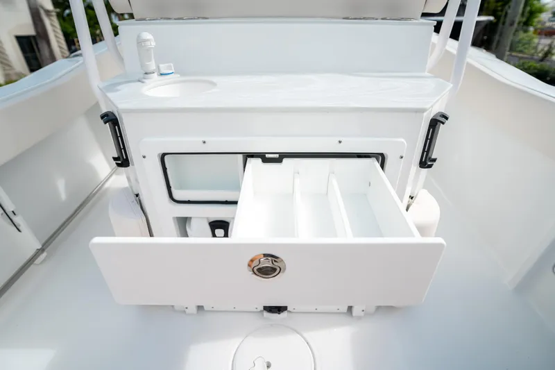 Slide: The Image of 2025 Sea Hunt Ultra 239 SE boat storage compartment with open drawers. - 21