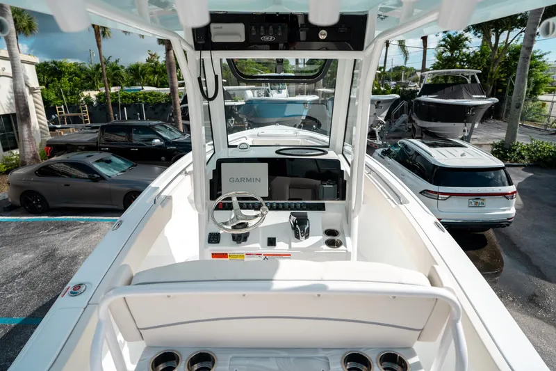 Slide: The Image of 2025 Sea Hunt Ultra 239 SE boat interior with Garmin navigation, parked in a lot. - 24