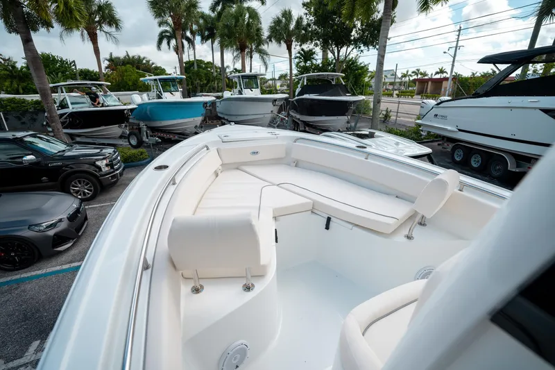 Slide: The Image of 2025 Sea Hunt Ultra 239 SE boat with white seating, parked among other boats and cars. - 34