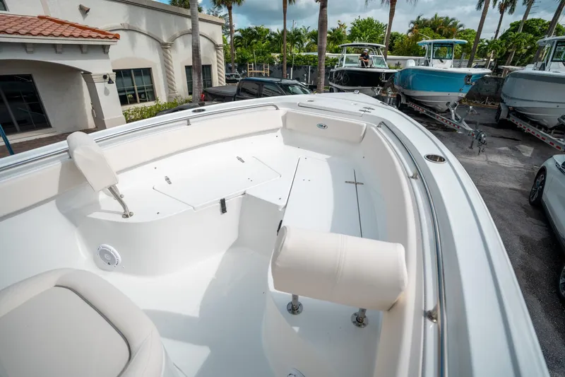 Slide: The Image of 2025 Sea Hunt Ultra 239 SE boat interior with seating, parked outdoors. - 40
