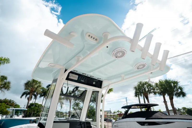 Slide: The Image of 2025 Sea Hunt Ultra 239 SE boat with T-top and rod holders under a blue sky. - 29
