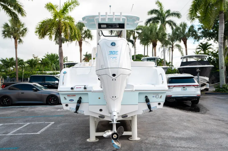 Slide: The Image of 2025 Sea Hunt Ultra 239 SE boat with powerful outboard motor, parked near palm trees. - 3