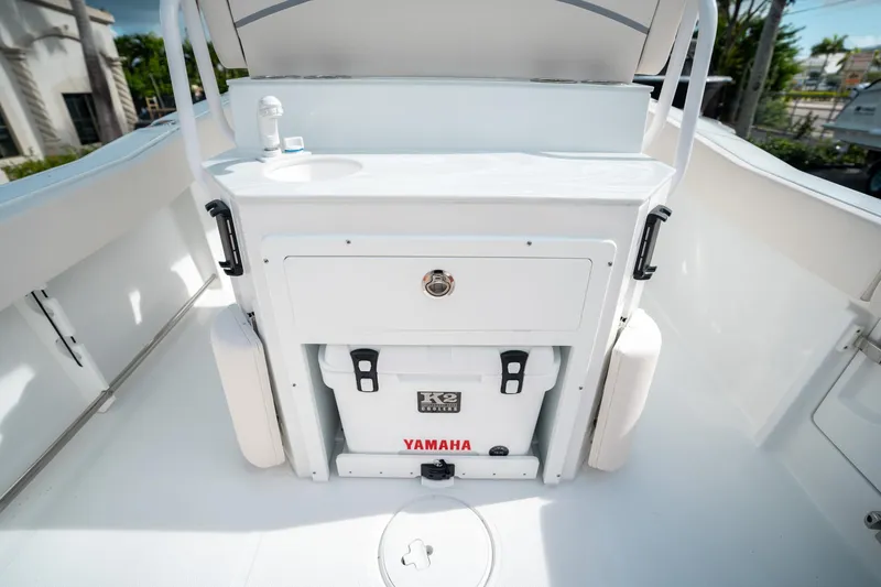 Slide: The Image of 2025 Sea Hunt Ultra 239 SE boat interior with storage compartment and Yamaha cooler. - 17