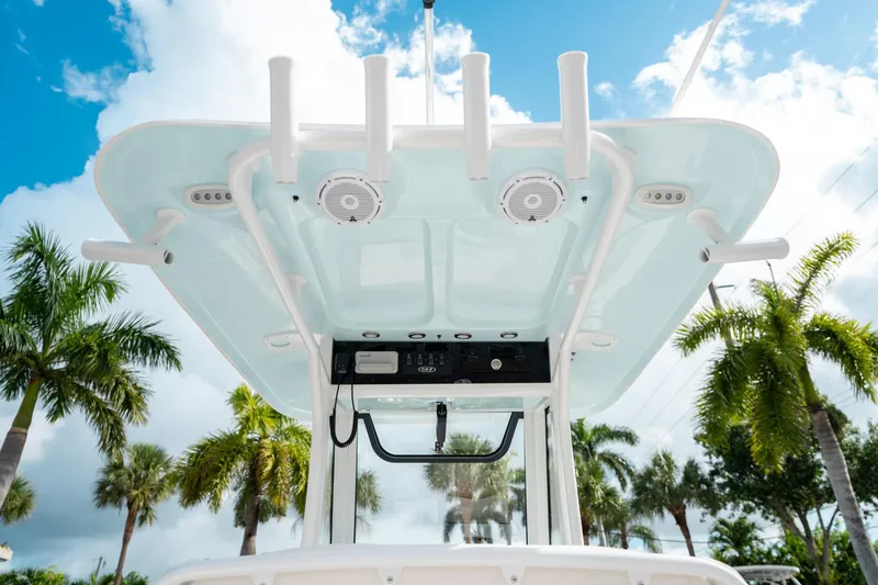 Slide: The Image of 2025 Sea Hunt Ultra 239 SE boat console with speakers, set against a tropical palm tree backdrop. - 27