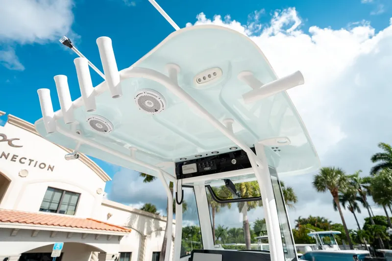 Slide: The Image of 2025 Sea Hunt Ultra 239 SE boat with rod holders and speakers under a clear blue sky. - 28
