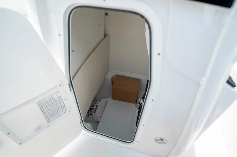 Slide: The Image of Storage compartment inside 2025 Sea Hunt Ultra 239 SE boat, featuring a cardboard box. - 31