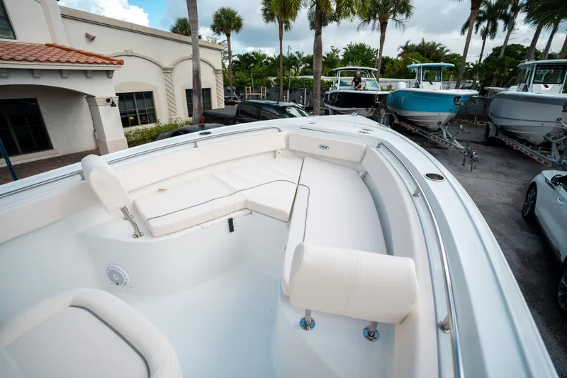 Slide: The Image of 2025 Sea Hunt Ultra 239 SE boat interior with white seating and palm trees in the background. - 35