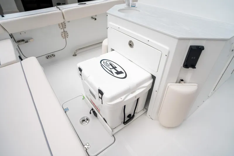 Slide: The Image of 2025 Sea Hunt Ultra 275 SE boat interior with cooler and seating area. - 19