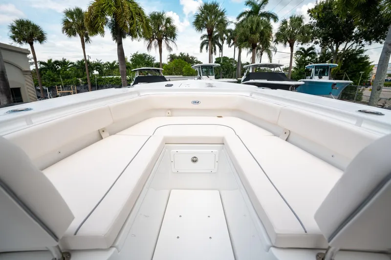 Slide: The Image of 2025 Sea Hunt Ultra 275 SE boat interior with white seating and palm trees in background. - 38