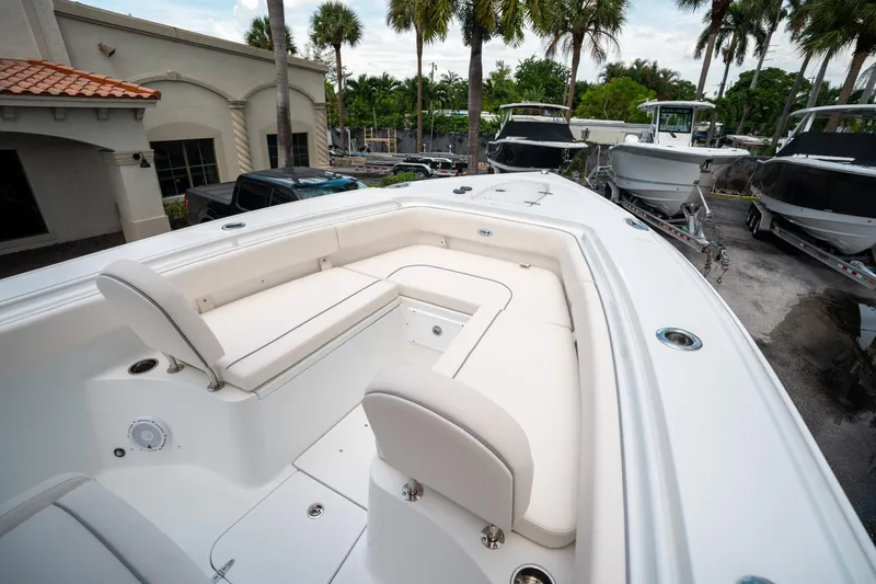Slide: The Image of 2025 Sea Hunt Ultra 275 SE boat interior with white seating and palm trees in background. - 37