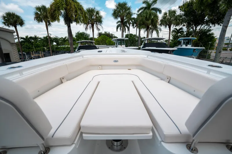 Slide: The Image of 2025 Sea Hunt Ultra 275 SE boat interior with white seating and palm trees in the background. - 41