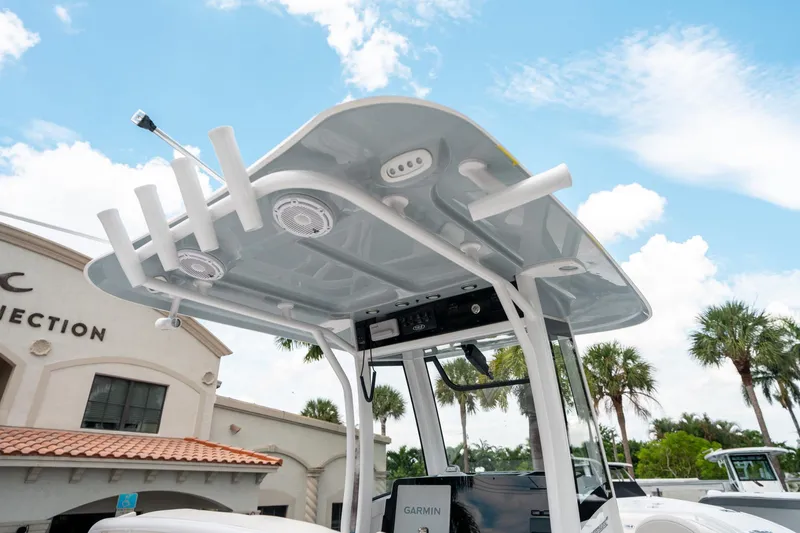 Slide: The Image of 2025 Sea Hunt Ultra 275 SE boat with T-top and rod holders under a blue sky. - 22