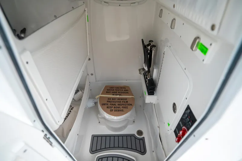 Slide: The Image of 2025 Sea Hunt Ultra 275 SE boat interior bathroom with protective film on toilet. - 35