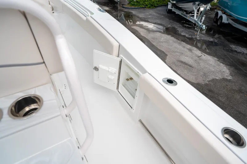 Slide: The Image of 2025 Sea Hunt Ultra 275 SE boat interior with storage compartment and cup holders. - 26