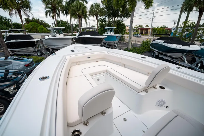 Slide: The Image of 2025 Sea Hunt Ultra 275 SE boat with spacious seating, surrounded by palm trees and other boats. - 36