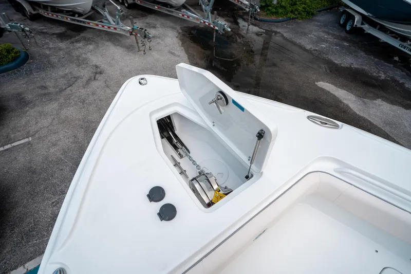 Slide: The Image of 2025 Sea Hunt Ultra 275 SE boat anchor compartment, open lid, showing chain and mechanism. - 49