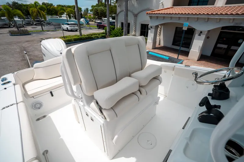 Slide: The Image of 2025 Sea Hunt Ultra 255 SE boat interior with white seating and steering wheel. - 29