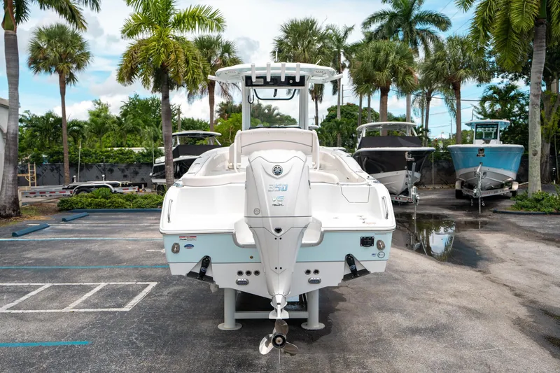 Slide: The Image of 2025 Sea Hunt Ultra 255 SE boat parked, surrounded by palm trees and other boats. - 3