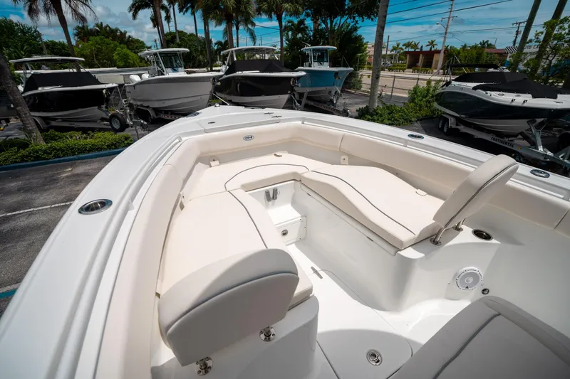 Slide: The Image of 2025 Sea Hunt Ultra 255 SE boat interior with cushioned seating, parked among other boats. - 35