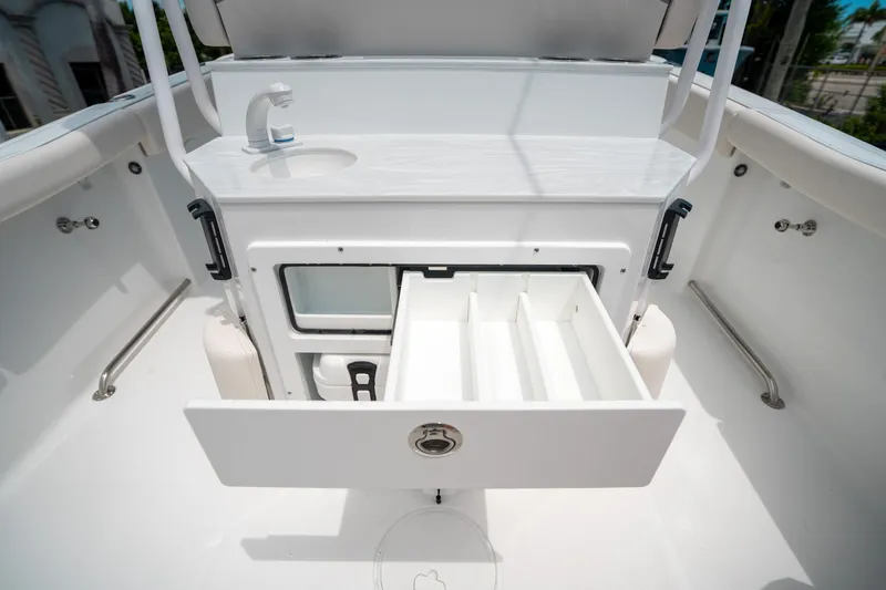 Slide: The Image of 2025 Sea Hunt Ultra 255 SE boat interior with storage compartment and sink. - 18