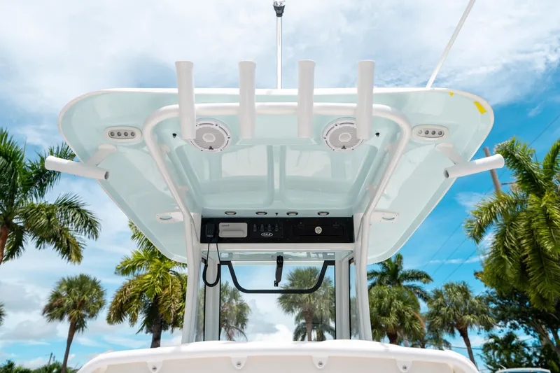 Slide: The Image of 2025 Sea Hunt Ultra 255 SE boat canopy with rod holders, set against a tropical backdrop. - 22