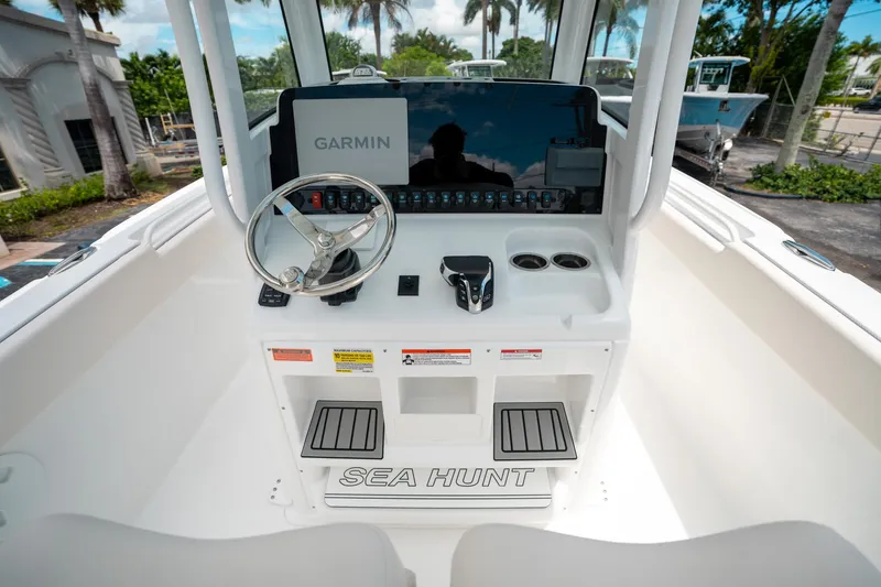 Slide: The Image of 2025 Sea Hunt Ultra 255 SE boat console with Garmin navigation system and steering wheel. - 25