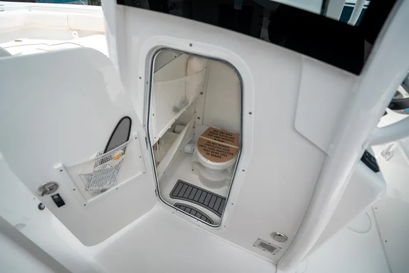 Slide: The Image of 2025 Sea Hunt Ultra 255 SE boat interior with compact marine toilet. - 32