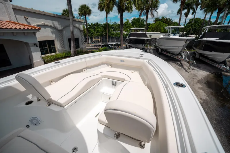 Slide: The Image of 2025 Sea Hunt Ultra 255 SE boat interior with white seating and palm trees in the background. - 36