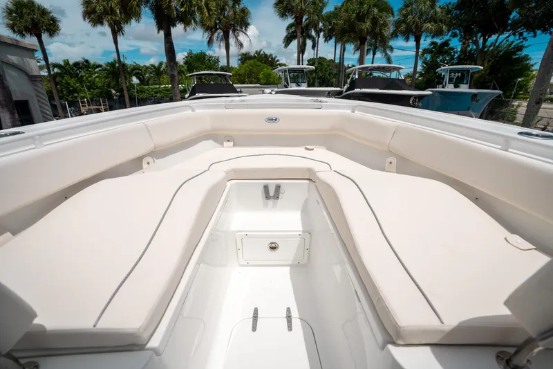 Slide: The Image of 2025 Sea Hunt Ultra 255 SE boat interior with cushioned seating and palm trees in the background. - 37