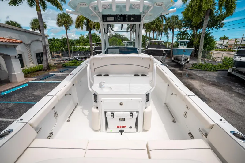 Slide: The Image of 2025 Sea Hunt Ultra 255 SE boat interior, featuring seating and console, parked outdoors. - 9